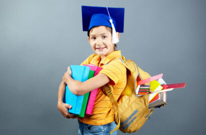 Portrait of happy schoolkid with backpack and books